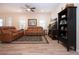 Cozy living room with wood-look floors, leather sofas, ceiling fan, bookcase and entertainment center at 5252 Bentgrass Way, Bradenton, FL 34211
