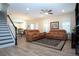 Spacious living room with wood-look flooring, comfortable leather sofas, and a staircase view at 5252 Bentgrass Way, Bradenton, FL 34211