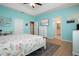 Primary bedroom featuring turquoise walls, wood floors, TV on dresser, and access to the bathroom at 5252 Bentgrass Way, Bradenton, FL 34211