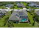 Aerial view of a home featuring a screened-in pool and solar panels, surrounded by lush landscaping and serene surroundings at 5603 90Th Avenue E Cir, Parrish, FL 34219
