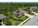 Aerial view of a landscaped home with a screened-in lanai and well-maintained lawns in a lush, green community at 5603 90Th Avenue E Cir, Parrish, FL 34219