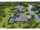 An aerial view of a home with solar panels and a screened-in pool in a lush, green neighborhood at 5603 90Th Avenue E Cir, Parrish, FL 34219