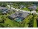 Aerial view of a home with solar panels, a screened-in pool, and lush greenery in a quiet neighborhood at 5603 90Th Avenue E Cir, Parrish, FL 34219