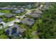 An aerial view showcasing a community with well-maintained homes, lush landscaping, and a serene pond at 5603 90Th Avenue E Cir, Parrish, FL 34219