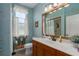 Bathroom with a marble countertop, wood vanity, framed mirror and window with natural light at 5603 90Th Avenue E Cir, Parrish, FL 34219
