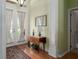 Cozy entryway featuring hardwood floors, a decorative rug, and a charming wooden table with a lamp and flowers at 5603 90Th Avenue E Cir, Parrish, FL 34219