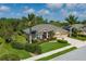Beautifully landscaped single-story home with a well-manicured lawn, mature palms, and a two-car garage at 5603 90Th Avenue E Cir, Parrish, FL 34219