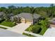 An exterior view showcases a single-story home with tropical landscaping and a driveway leading to a two-car garage at 5603 90Th Avenue E Cir, Parrish, FL 34219