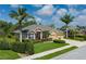 Charming home exterior with a well-kept lawn, palm trees, neatly trimmed shrubs, and a double garage at 5603 90Th Avenue E Cir, Parrish, FL 34219