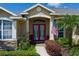 Close view of the front entry featuring a red door, stacked stone accents, and manicured landscaping at 5603 90Th Avenue E Cir, Parrish, FL 34219