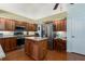 Well-equipped kitchen featuring an island, stainless steel appliances, wooden cabinetry, and hardwood flooring at 5603 90Th Avenue E Cir, Parrish, FL 34219