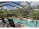 Screened-in pool with lounge chairs and view of backyard greenery at 5603 90Th Avenue E Cir, Parrish, FL 34219