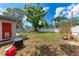 Spacious backyard features a lush green lawn, mature trees, and full fencing at 5732 Beneva Rd, Sarasota, FL 34233