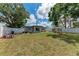 The large backyard features mature trees, a lush green lawn, and a tall white fence at 5732 Beneva Rd, Sarasota, FL 34233