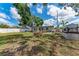 Backyard view with mature trees, a lush green lawn, full perimeter fencing and storage at 5732 Beneva Rd, Sarasota, FL 34233