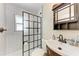 Bathroom features a modern vanity, black grid shower door, and white tiled walls at 5732 Beneva Rd, Sarasota, FL 34233