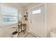 Welcoming entryway featuring a decorative front door, side window, and accent table with plants at 5732 Beneva Rd, Sarasota, FL 34233