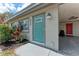Charming front door with decorative glass, complemented by fresh landscaping and a convenient carport at 5732 Beneva Rd, Sarasota, FL 34233