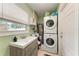 A spacious laundry room featuring updated machines, storage, and a window at 5732 Beneva Rd, Sarasota, FL 34233