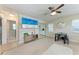 A sunlit living room with a ceiling fan, tiled floors, and a TV mounted over a storage cabinet at 5732 Beneva Rd, Sarasota, FL 34233
