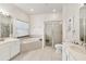 Bright bathroom featuring dual sinks, a garden tub, a glass-enclosed shower, and tile flooring at 5915 43Rd E Ct, Bradenton, FL 34203