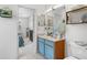 Bathroom with blue vanity, a single sink, a large mirror, and a bedroom view at 5915 43Rd E Ct, Bradenton, FL 34203