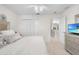 Bright bedroom featuring neutral tones, a ceiling fan, double closet, and a silver-framed headboard at 5915 43Rd E Ct, Bradenton, FL 34203
