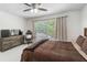 Bedroom featuring a ceiling fan, a window with blinds, and a comfortable bed at 5915 43Rd E Ct, Bradenton, FL 34203