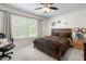 Bedroom featuring a ceiling fan, a window with blinds, and a comfortable bed at 5915 43Rd E Ct, Bradenton, FL 34203