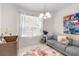 Bedroom with floral rug, gray couch, window with sheer curtains, decorative art and chandelier at 5915 43Rd E Ct, Bradenton, FL 34203