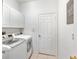 Bright laundry room with white cabinets, a modern washer and dryer and a white door at 5915 43Rd E Ct, Bradenton, FL 34203