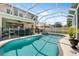 Screened-in pool area with turquoise water, lounge chairs, hot tub and fenced surround at 5915 43Rd E Ct, Bradenton, FL 34203