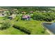 Aerial view of backyard and screened in pool with expansive lawn that leads to pond at 618 148Th Ne Ct, Bradenton, FL 34212