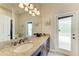 Bathroom with granite countertops, dark wood cabinetry, large mirror, and access to the outdoors at 618 148Th Ne Ct, Bradenton, FL 34212