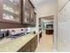 Hallway featuring granite counters, glass-front cabinets, and views into the living area at 618 148Th Ne Ct, Bradenton, FL 34212