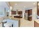 Kitchen featuring a peninsula with bar seating, stainless steel appliances, and dark wood cabinetry at 618 148Th Ne Ct, Bradenton, FL 34212