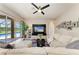 Bright living room showcasing a large sectional sofa, entertainment center, and pool views through sliding glass doors at 618 148Th Ne Ct, Bradenton, FL 34212