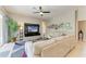 Comfortable living room with neutral tones, a modern entertainment center, and access to the outdoor patio at 618 148Th Ne Ct, Bradenton, FL 34212