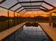 Covered pool at dusk with string lights, water features, and views of the landscape at 618 148Th Ne Ct, Bradenton, FL 34212