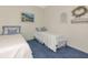 The cozy bedroom features two twin beds, blue carpet, and light blue accents at 6442 Tailfeather Way, Bradenton, FL 34203