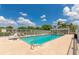 Community pool with clear blue water, lounge chairs, and white fencing for relaxation at 6442 Tailfeather Way, Bradenton, FL 34203
