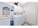 Bright laundry room with cabinetry, sink, washer, and dryer with beach themed decor at 6442 Tailfeather Way, Bradenton, FL 34203