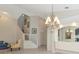 Elegant living area with staircase, chandelier, large mirror, and neutral tones creates a spacious atmosphere at 6442 Tailfeather Way, Bradenton, FL 34203