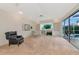 Sunlit living room with plush carpet, built-in shelving, and views of the pool offers relaxation and entertainment at 6442 Tailfeather Way, Bradenton, FL 34203