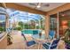 Relaxing screened patio with dining table and chairs overlooking the sparkling pool at 6442 Tailfeather Way, Bradenton, FL 34203