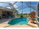 Outdoor screened-in pool features crystal clear water, a spa, palm trees, and lounge chairs at 6442 Tailfeather Way, Bradenton, FL 34203