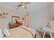 Cozy bedroom with wood floors, features a dresser with TV, closet, and a work space with a desk and chair at 6600 Horned Owl Pl, Sarasota, FL 34241