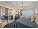 Beautiful bedroom featuring tray ceilings, chandelier, and an adjacent lanai with a large sliding glass door at 6600 Horned Owl Pl, Sarasota, FL 34241