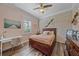 Comfortable bedroom with wood flooring, beach-themed decor, and a wooden dresser creating a serene and inviting retreat at 6600 Horned Owl Pl, Sarasota, FL 34241