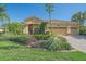 Charming single-story home featuring a terracotta roof, manicured landscaping, and an inviting front entrance at 6600 Horned Owl Pl, Sarasota, FL 34241
